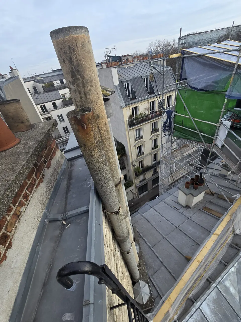 Conduit en fibro-ciment vétuste déposé sur une toiture parisienne avant évacuation